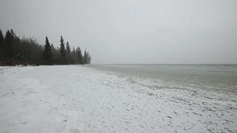 View along the shoreline of a partial frozen large lake Stock Footage 142975889