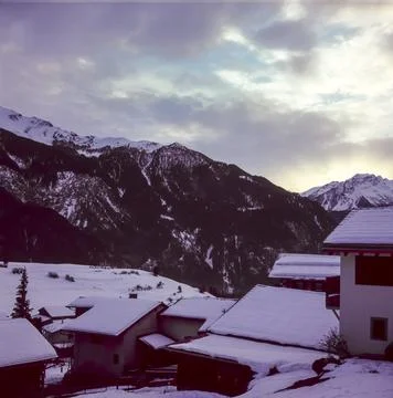 View of the Alpine mountain range in winter from the top of the village of Al Stock Photos