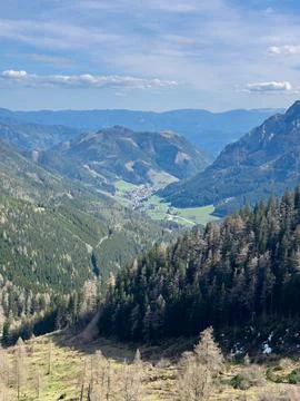 View of the Alpine valley from the top of one of the mountains against the sk Stock Photos