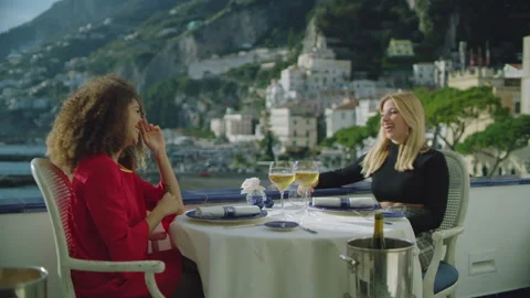 With a view of the Amalfi coast in the background, two beautiful chatty friends Stock Footage 199459275