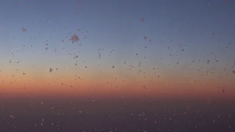 View of amazing orange sunlight at sunset icy water frozen on airplane window Stock Footage 81980198