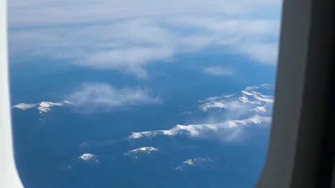 View of amazing snow capped mountain range from airplane window Stock Footage 338095504