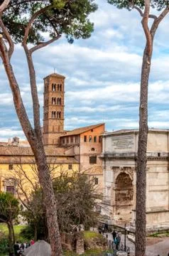 View on ancient cathedral between the trees with blue cloudy sky on the backg Stock Photos