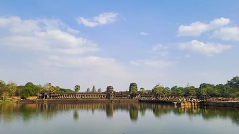 View of Angkor Wat temple reflected in water under a blue sky Stock Photos