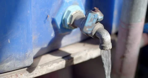View angle oblique. Old blue faucet open that attached to the bucket of blue. Stock Footage 253105737