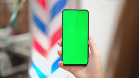 View of an anonymous client holding a green screen smartphone in his hand. Mocap Stock Footage 236629227