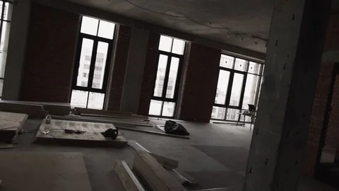 View of apartment with big black framed windows, planks on floor and scaffolding Stock Footage 99612863