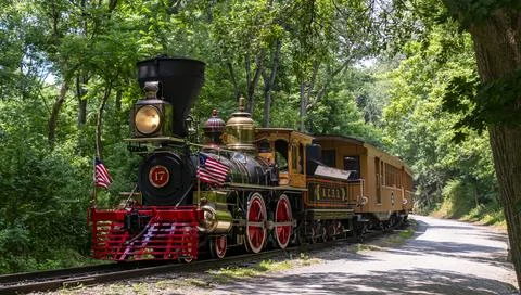 View of an Approaching Steam Passenger Train Blowing Smoke on a Sunny Summer Day Stock Photos