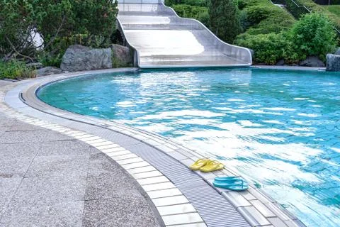 View of the aqua slide and the pool on the edge of which are yellow and blue  Stock Photos