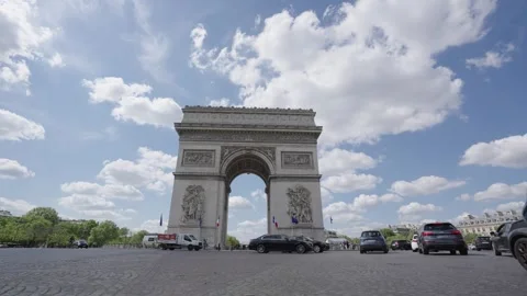 View of the Arc de Triomphe with its intricate stone carvings, French flags Stock Footage 345995124
