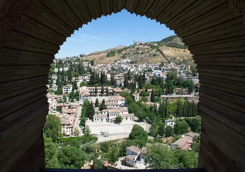 View from an arched window across a pretty town. Stock Photos