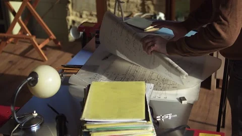 View of the architect's desk with the building plan and unpacking the next Stock Footage 179244952