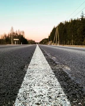 View of an asphalt road with a white solid line behind it. Stock Photos