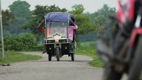 View of an auto-rickshaw driving on a rural road in Bangladesh. 스톡 동영상 334978194