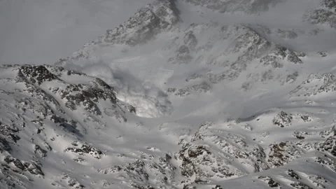 View of an avalanche rolling down a snowy mountain in the Swiss alps in Stock Footage 205457701