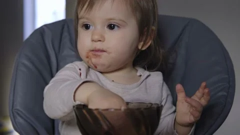 From view baby grabbing with hands empty bowl after finishing food snack Stock Footage 197737953