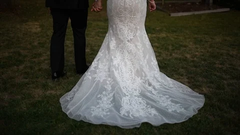 View from the back, the bride and groom walk and the train dress on the ground Stock Footage 103193463