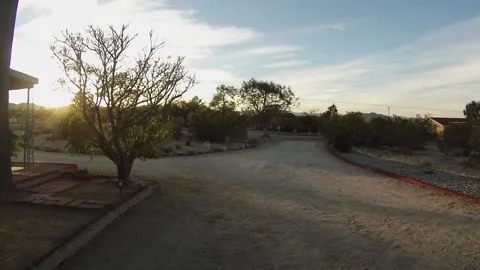 View from back of car parked in dirt driveway of house in Yucca Valley Stock Footage 160811638