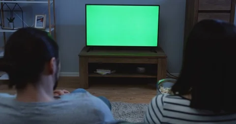 View from the back on the couple watching TV with green screen and eating 스톡 동영상 90200045