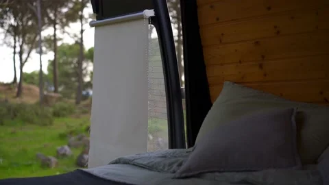 View from the back doors and a bed on a camper van in nature with green trees Stock Footage 225659215