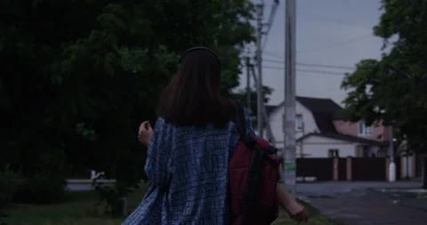 The view from the back, the girl is dancing in the evening on the street Stockbeeldmateriaal 120843379