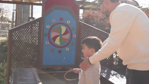 View from back. Happy loving dad teaches his small son to throw a ring at a Stock Footage 244635269