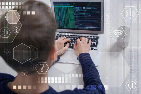 A view from the back of a male programmer working in an office. Stock Photos