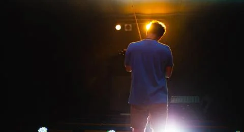 View from the back of a man playing the violin on stage Stock Photos