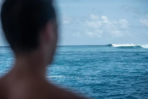View from the back man surfer watching to the blue perfect waves from the boa Stock Photos