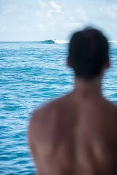 View from the back man surfer watching to the blue perfect waves from the boa Stock Photos