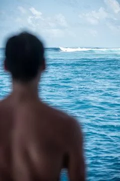View from the back man surfer watching to the blue perfect waves from the boa Stock Photos