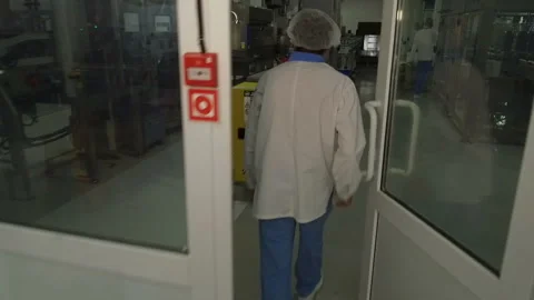 View from the back of a man walking along the conveyor with the finished product Stock Footage 98716726