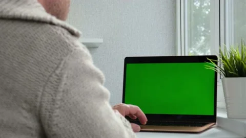 View from the back of man in warm sweater sitting at the table and typing on Stock Footage 163160651