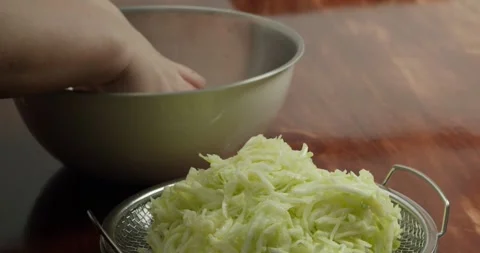 View back on the peel the zucchini. 4K close-up: A chef transfers sliced Stock Footage 317327896
