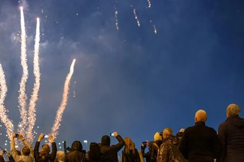 View from the back at people in wark clothes shooting fireworks on the phone at Stockfoto's