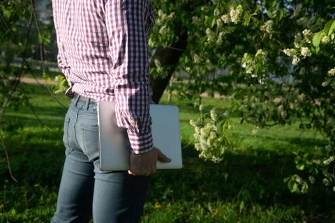 View from the back, Portrait of a young blond European man holding a laptop i Stock Photos