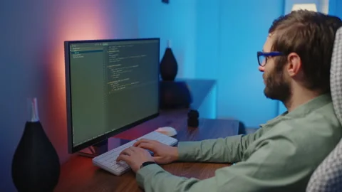 The view from the back of the programmer at work can be seen as the fingers type Stock Footage 228942897