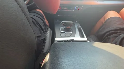 View from back seat of car interior showing driver and front passenger legs with Stock Footage 344846402