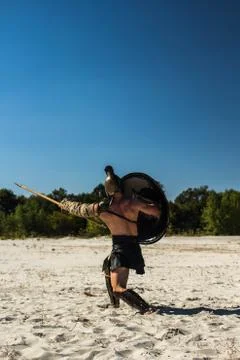 View from the back to the Spartan with a shield on the trampled field Stock Photos