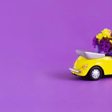View of the back of the trunk of a bright yellow convertible car with a bouqu Stock Photos