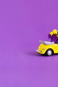 View of the back of the trunk of a bright yellow convertible car with a bouqu Stock Photos
