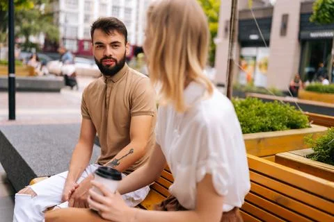 View from back of unrecognizable blonde young woman to handsome bearded man Stock Photos