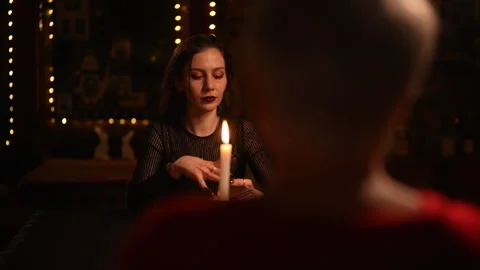View from back of unrecognizable client to mysterious fortuneteller doing Tarot Stock Footage 276192850
