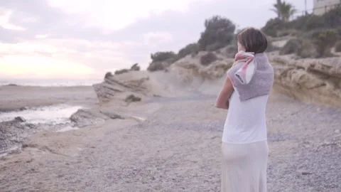 View from the back, a woman throws a warm sweater over her shoulders in the Stock Footage 254418562