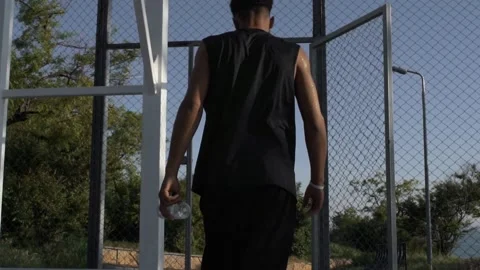 View from back on young black man going away from basketball playground 動画素材 160476456
