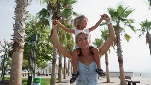View back young mother with his little son sitting on parent shoulders in field Stock Footage 249339459