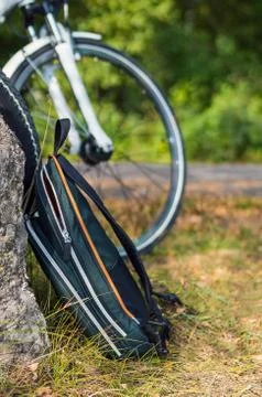 View of backpack with bicycle at the background Stock Photos