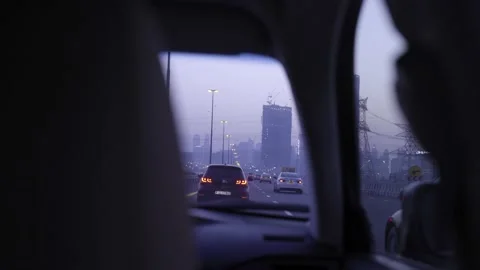 View from backseat of car driving through city at dusk Stock Footage 146929563