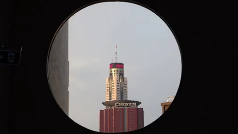 A view of the Baiyoke skyscraper through an round window in a high-rise building Stock Footage 314062254