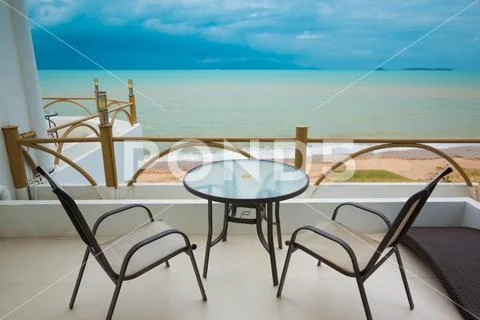 View from balcony on Blue ocean and sand beach under cloudy sky Stock Photos